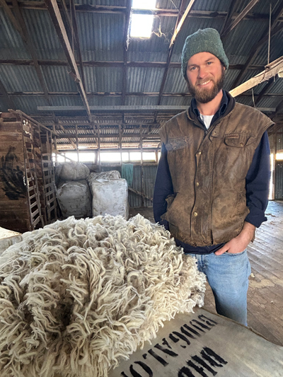 A person standing next to a pile of Merino wool