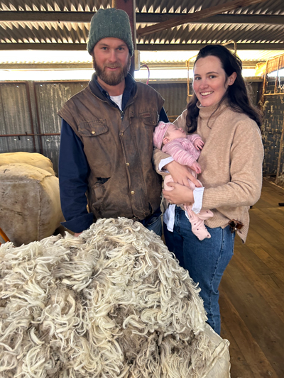 A Woolgrower Family standing in front of a pile of Merino Wool