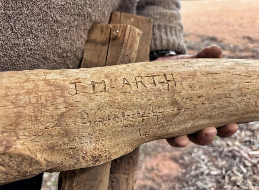 Close-up of a historic wooden tool with J M Arth carved into the handle, reflecting Holowiliena Station’s multi-generational pastoral heritage