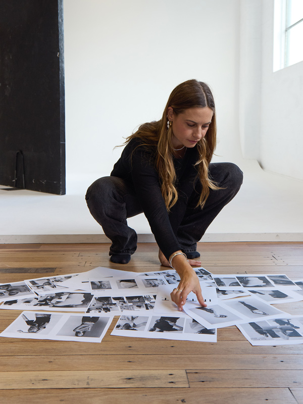 Gabby Neal reviewing fashion photo prints on the floor in a studio workspace