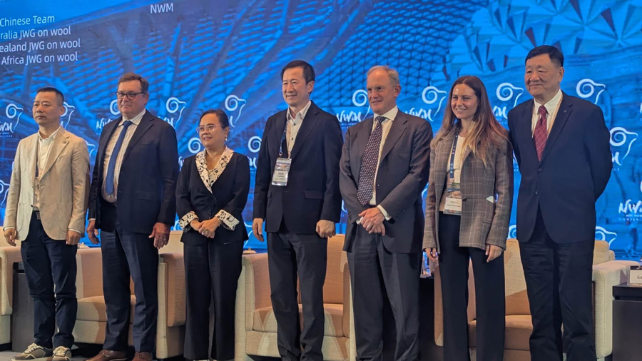 International wool industry leaders standing on stage at a global wool conference