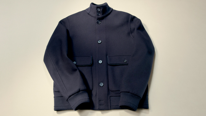 The finished Tod's 15-micron wool double bomber jacket in navy, showcasing its structured high collar, button-down front, and large patch pockets.