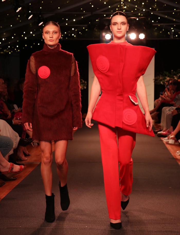 Models walking the runway in red wool garments at the Fleece to Fashion event